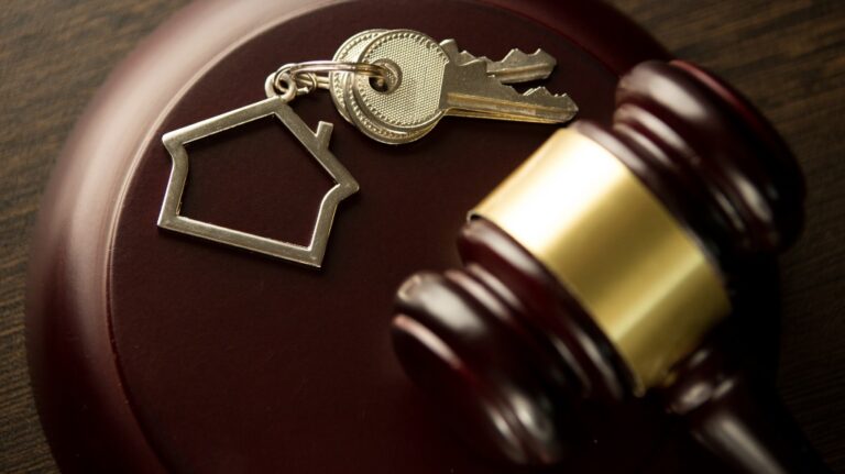 gavel on a desk with house keys